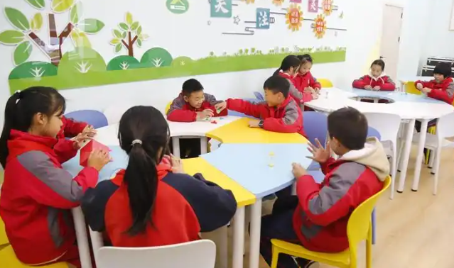 >同学们正一起拼搭心情积木五颜六色的积木块在他们手中逐渐成型